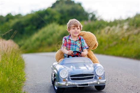 小男孩开玩具车在马路上